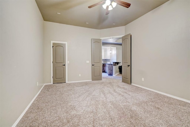 unfurnished bedroom with light carpet, ceiling fan, and baseboards