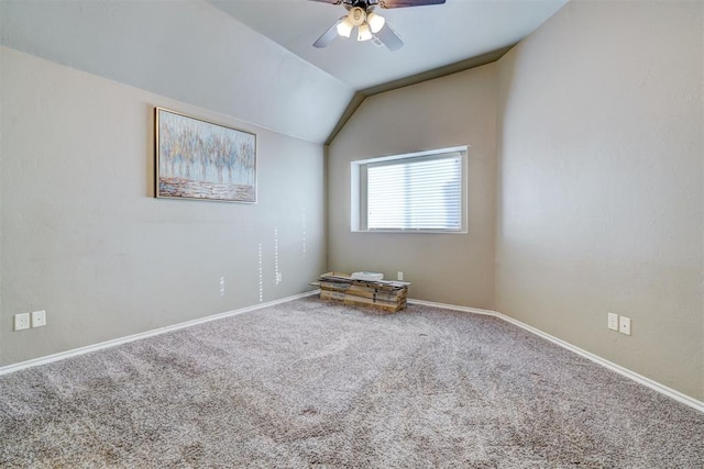 carpeted empty room featuring lofted ceiling, ceiling fan, and baseboards