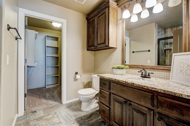 bathroom with baseboards, decorative backsplash, toilet, vanity, and a shower stall