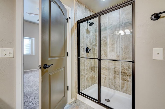 bathroom featuring tiled shower and baseboards