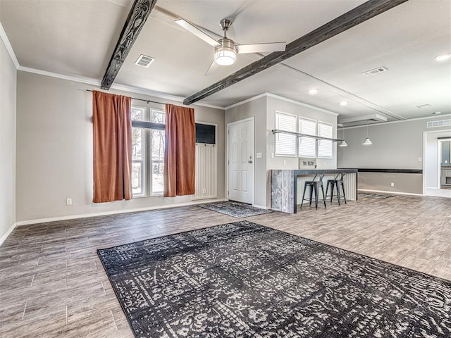 interior space featuring wood finished floors, visible vents, baseboards, a ceiling fan, and beamed ceiling