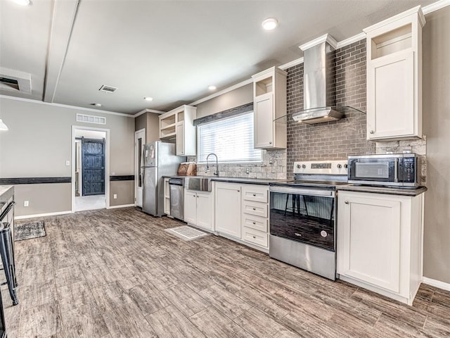 kitchen featuring dark countertops, wall chimney exhaust hood, glass insert cabinets, and stainless steel appliances