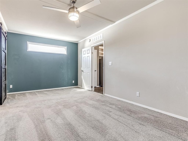 spare room featuring ceiling fan, carpet floors, ornamental molding, and baseboards