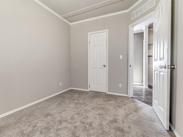 unfurnished room with baseboards, visible vents, carpet flooring, and ornamental molding