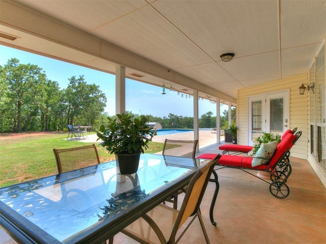 view of patio with french doors, outdoor dining space, and an outdoor pool