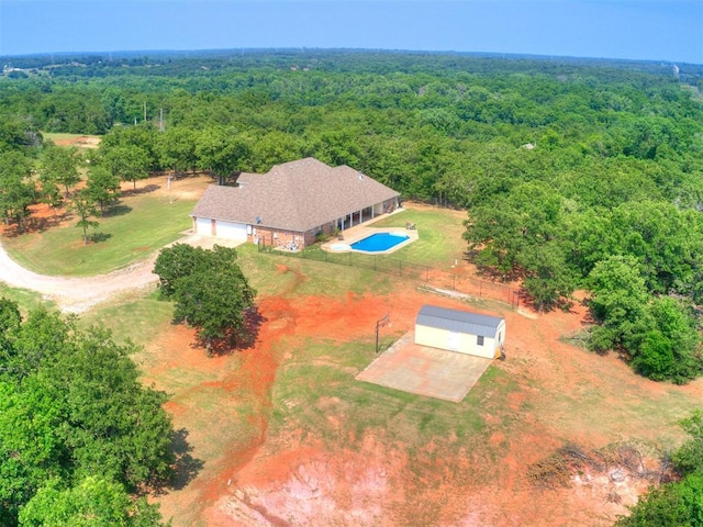 bird's eye view with a wooded view