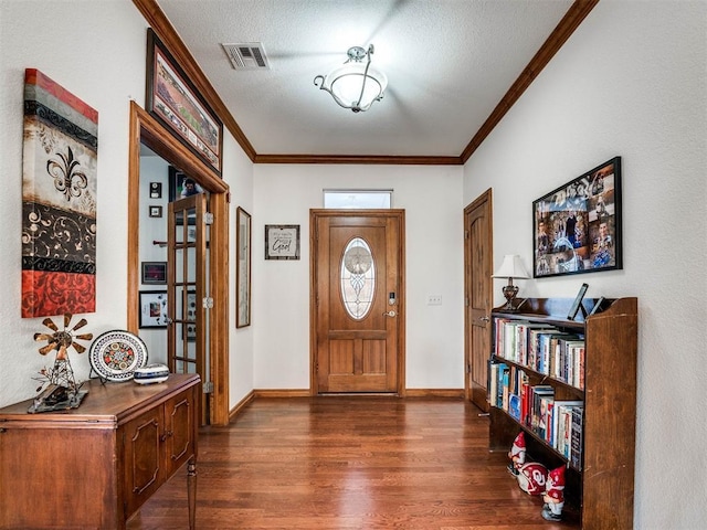 foyer entrance featuring baseboards, visible vents, dark wood finished floors, and crown molding