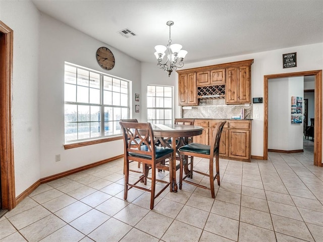 dining space with visible vents, a notable chandelier, baseboards, and light tile patterned floors