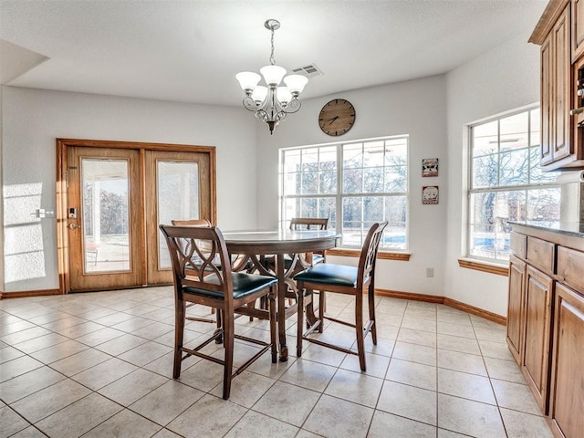 dining area with light tile patterned floors, visible vents, baseboards, and a chandelier