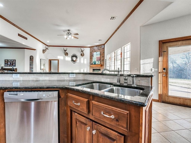 kitchen with visible vents, dishwasher, dark stone countertops, a sink, and light tile patterned flooring