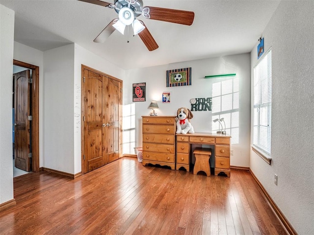 office featuring light wood finished floors, baseboards, and a textured wall