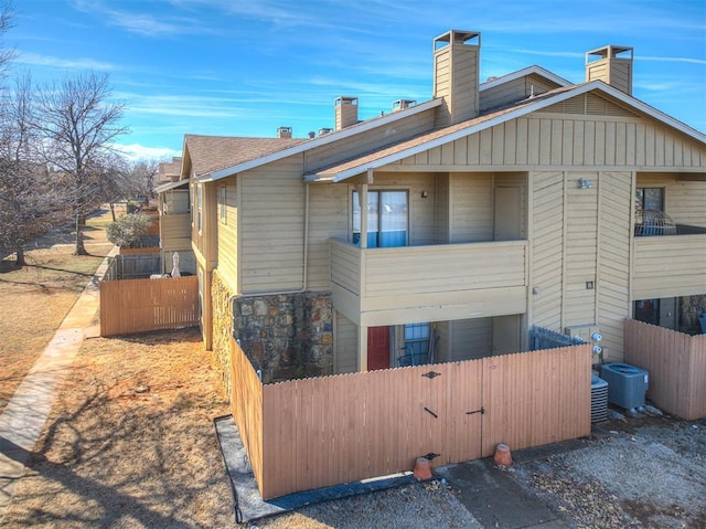 view of home's exterior with cooling unit and fence