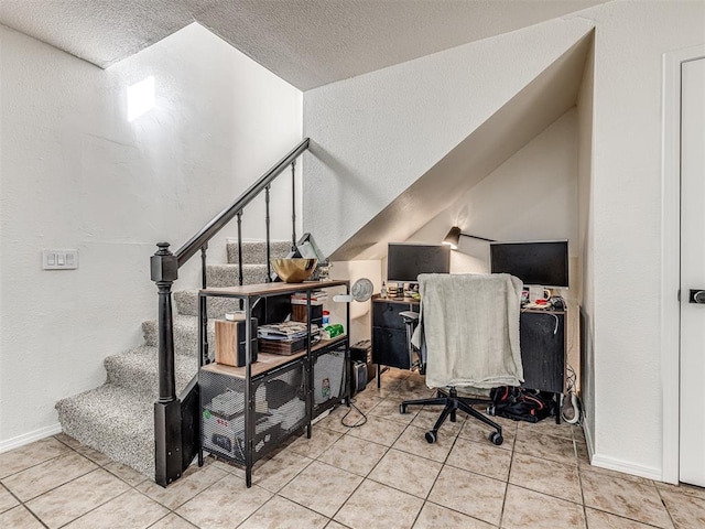 office with a textured wall, a textured ceiling, baseboards, and light tile patterned floors