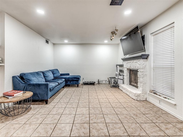 living room with light tile patterned floors, a fireplace, and visible vents