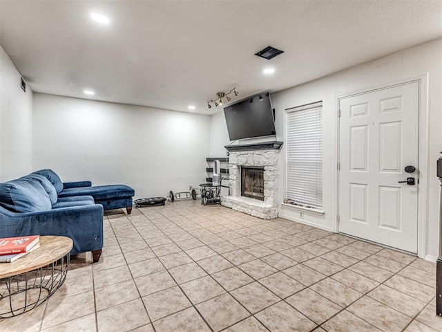 living area featuring recessed lighting, light tile patterned flooring, a fireplace, and track lighting