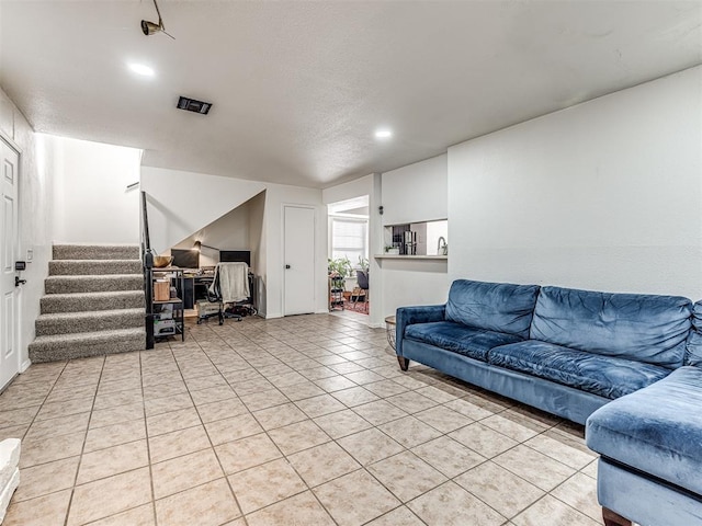 living area with recessed lighting, light tile patterned flooring, and stairs