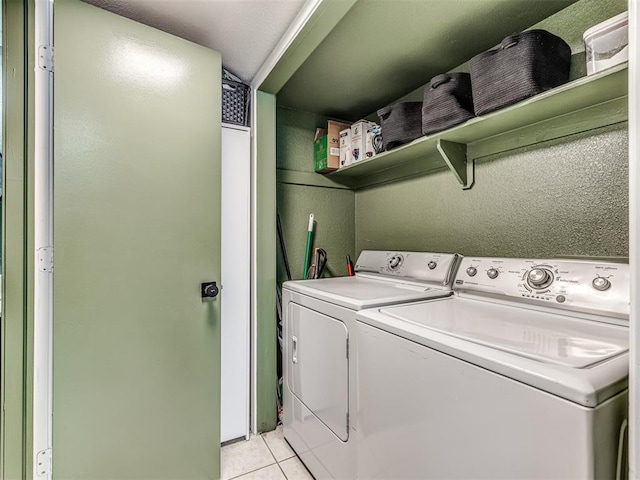 washroom with laundry area, washer and dryer, and light tile patterned flooring