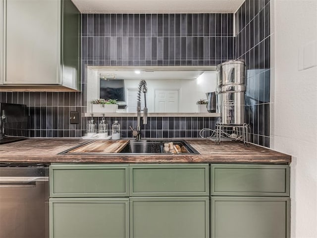 kitchen with decorative backsplash, green cabinets, a sink, and stainless steel dishwasher