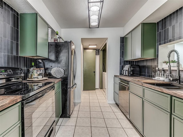 kitchen featuring light tile patterned flooring, electric range, a sink, green cabinets, and dishwasher