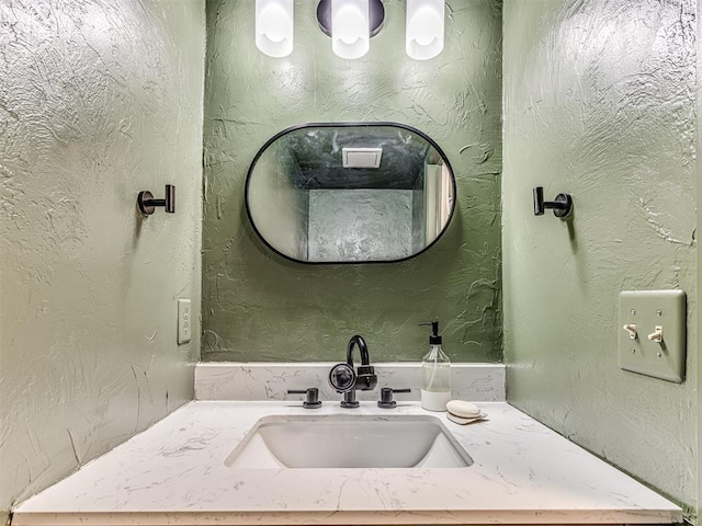 bathroom featuring vanity and a textured wall