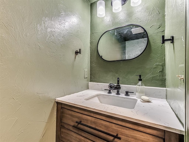 bathroom featuring a textured wall and vanity