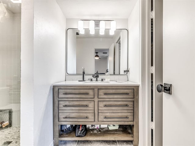 full bath featuring a ceiling fan, tiled shower, and vanity