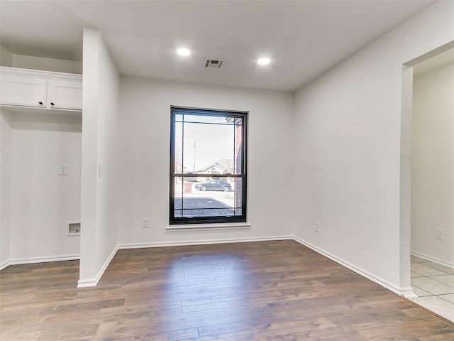 empty room with recessed lighting, visible vents, baseboards, and wood finished floors