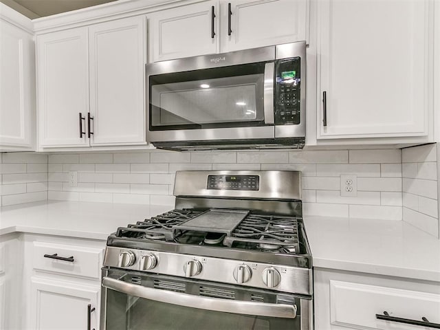 kitchen with light countertops, appliances with stainless steel finishes, white cabinetry, and decorative backsplash