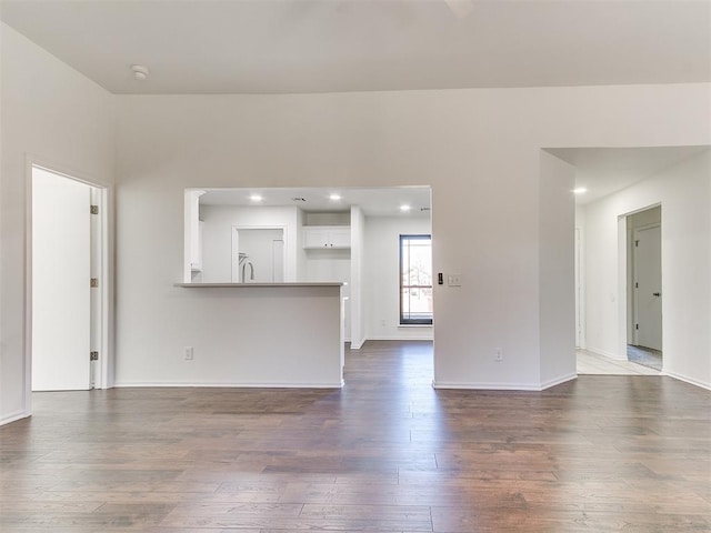 unfurnished living room with baseboards, dark wood-style flooring, and recessed lighting