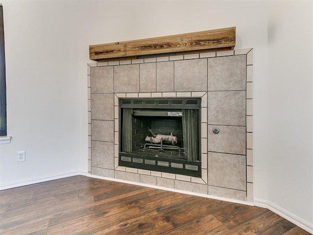 details featuring a fireplace, wood finished floors, and baseboards