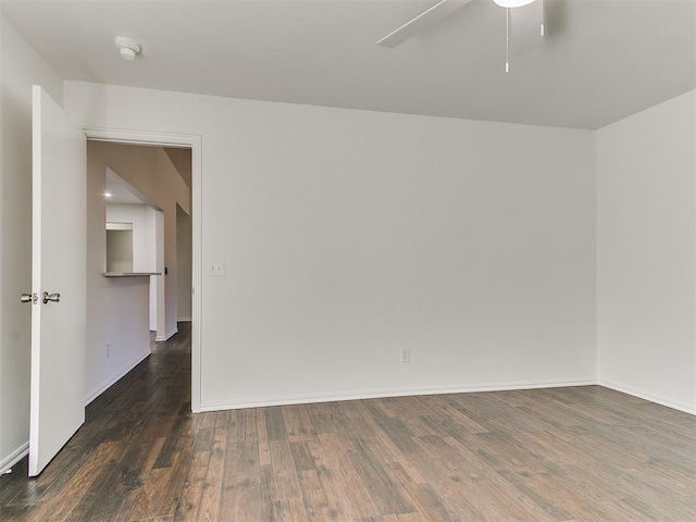 empty room with ceiling fan, wood finished floors, and baseboards