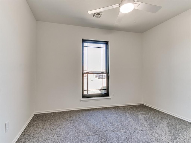 unfurnished room featuring ceiling fan, carpet floors, visible vents, and baseboards