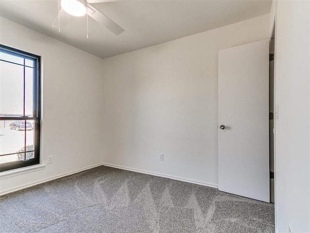 spare room featuring carpet, baseboards, and ceiling fan