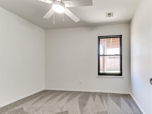 empty room with ceiling fan, carpet floors, visible vents, and baseboards