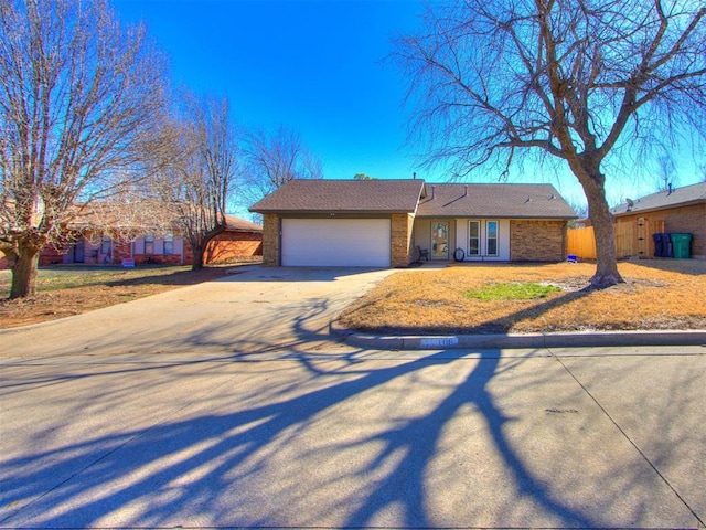 ranch-style house featuring brick siding, driveway, and a garage