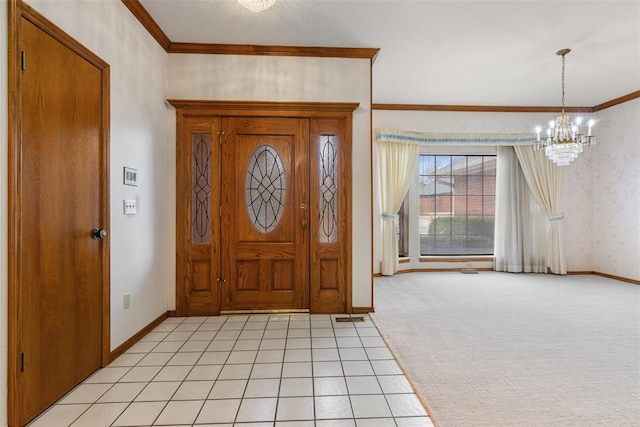 foyer with an inviting chandelier, baseboards, ornamental molding, and light colored carpet