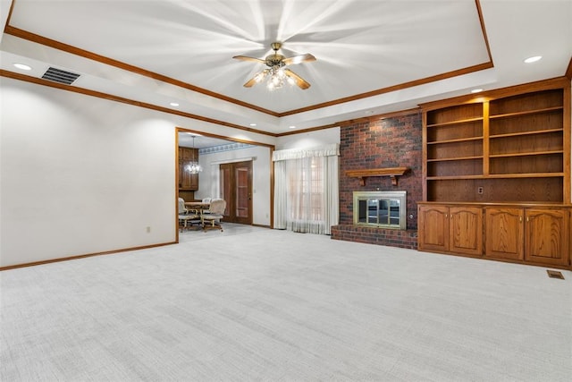 unfurnished living room featuring carpet floors, a raised ceiling, ornamental molding, a brick fireplace, and baseboards