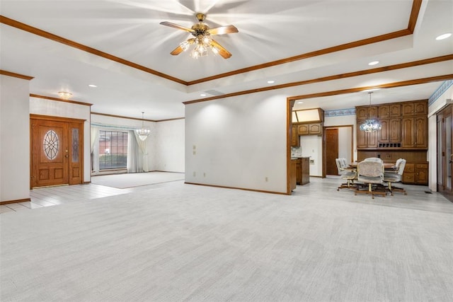 unfurnished living room with a raised ceiling, crown molding, and light colored carpet