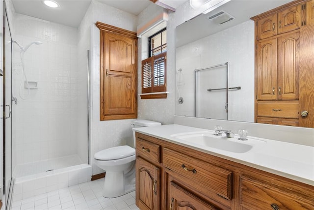 full bath featuring toilet, visible vents, vanity, tile patterned floors, and a stall shower