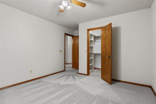 unfurnished bedroom featuring light carpet, ceiling fan, a closet, and baseboards