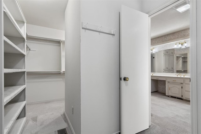 spacious closet featuring a sink, carpet flooring, and visible vents