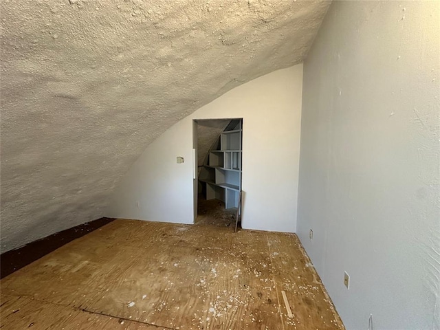 bonus room with lofted ceiling and a textured ceiling