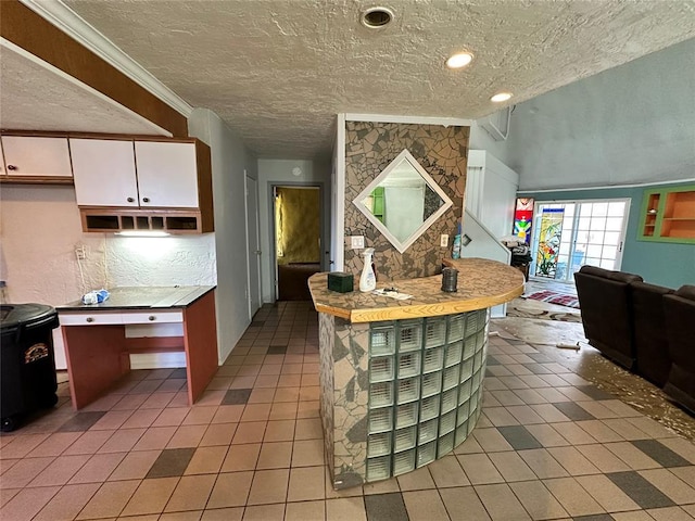 kitchen featuring white cabinetry, a textured ceiling, and tile patterned floors