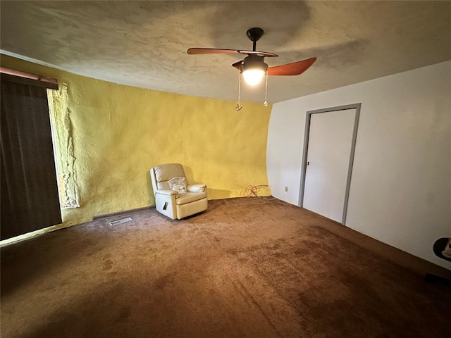 unfurnished room featuring carpet, visible vents, and a ceiling fan