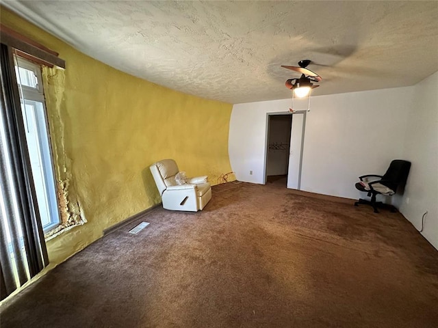 unfurnished room featuring carpet floors, visible vents, and a textured ceiling