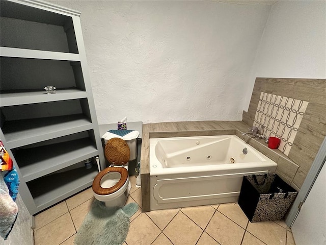 bathroom featuring a textured wall, a tub with jets, and tile patterned floors