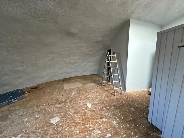 bonus room with a textured ceiling