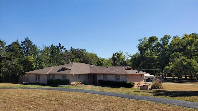 single story home featuring a front lawn