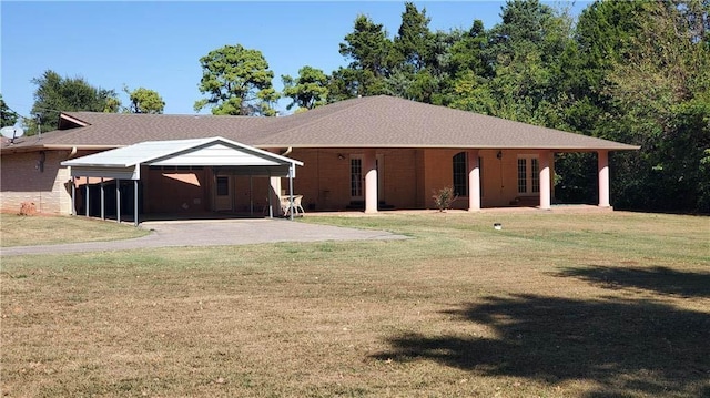 back of property with a carport and a lawn