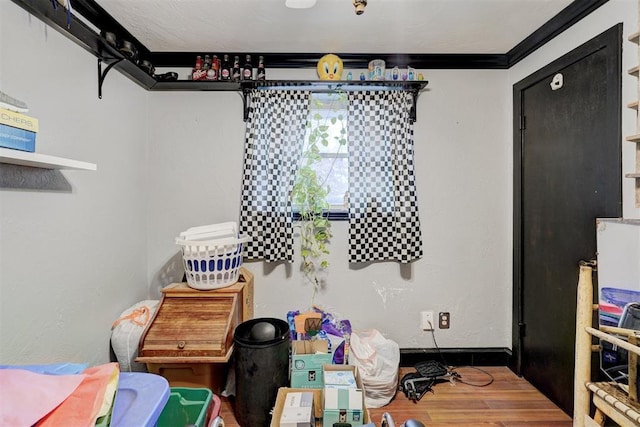 interior space with crown molding, baseboards, and wood finished floors